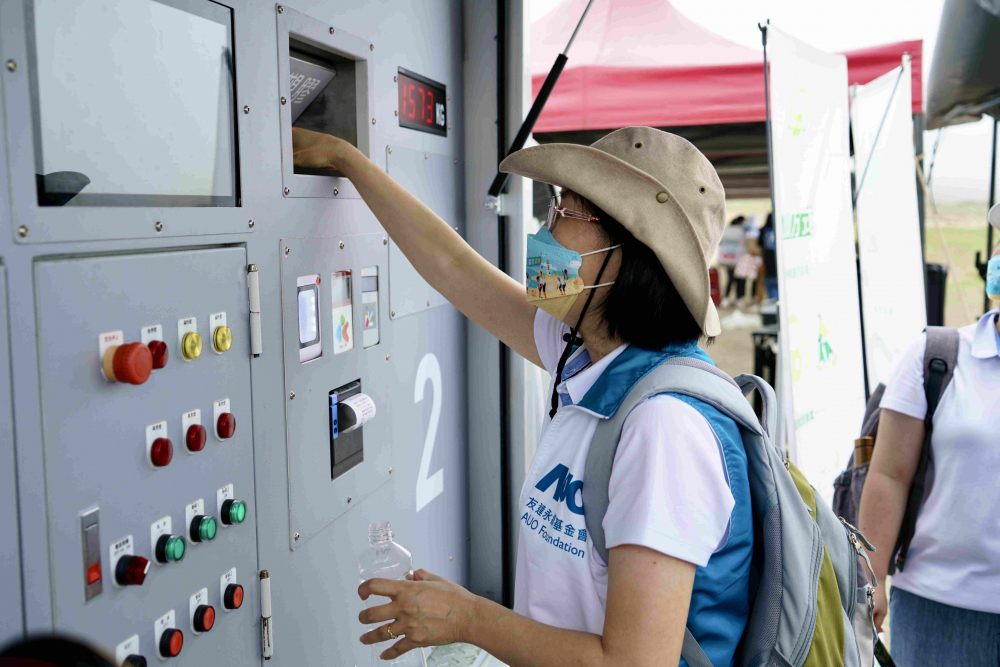 志工們將拾起的寶特瓶投入「好歸塑專車」，讓廢棄塑料空瓶可以直接粉碎、縮小體積，未來將可再製成購物袋、寶特衣、悠遊卡等生活用品
